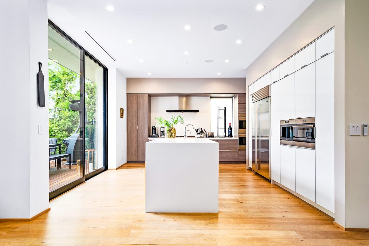 Professional real estate photo of a modern kitchen with a white waterfall island